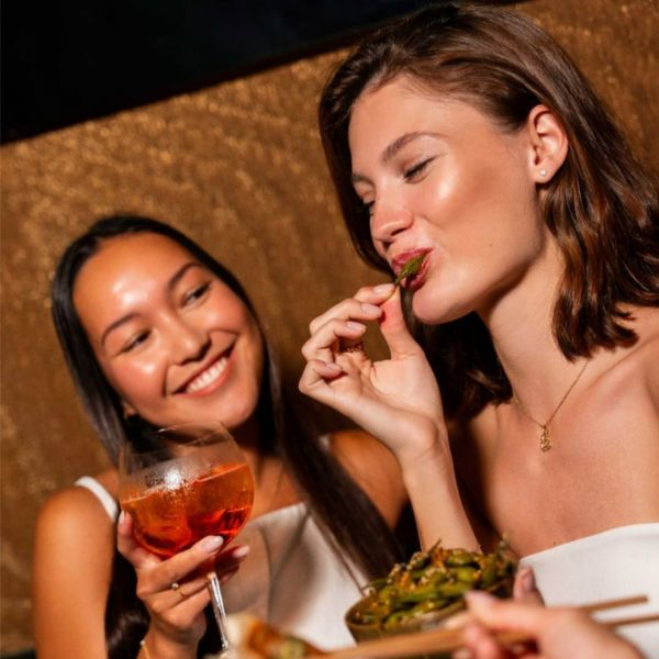 Two women enjoying cocktails and gourmet tapas at El Baron Saigon Lounge