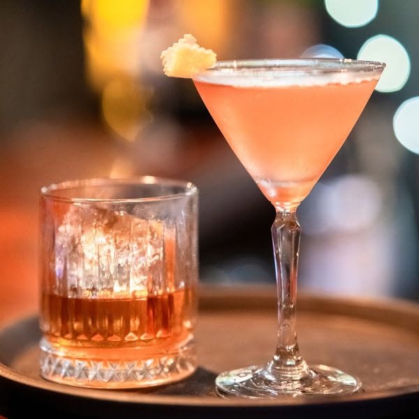 Mixologist crafting a signature cocktail with clear ice in District 7