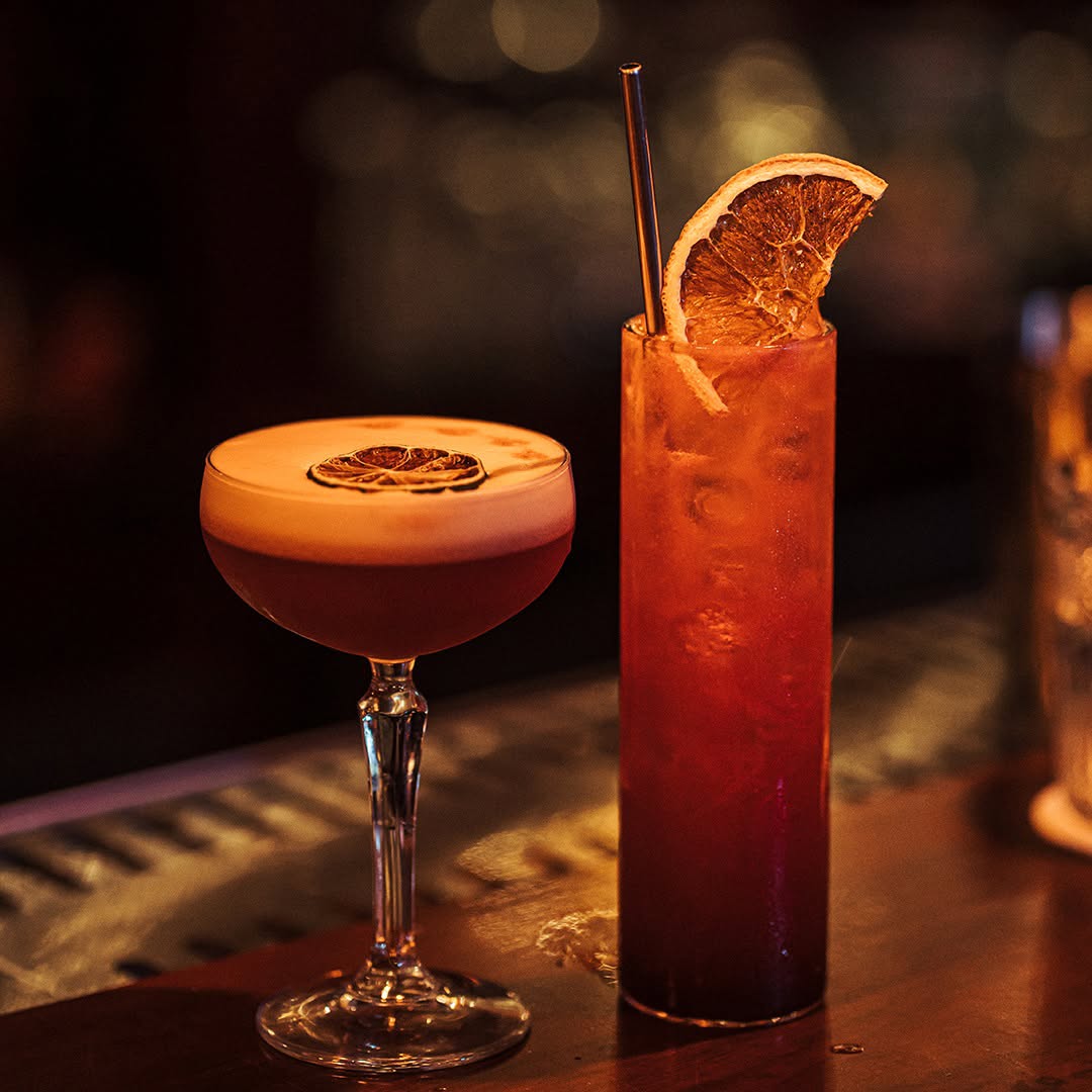 Mixologist crafting a signature cocktail with clear ice in District 7